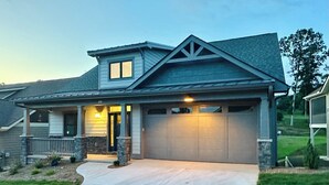 A two-story house with a garage, a covered porch, and a well-maintained lawn. - Spacious mountain getaway on golf course, near trails, waterfalls & breweries! (Laurel Park)