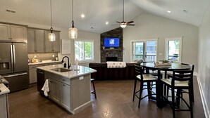 A modern kitchen with granite countertops, stainless steel appliances, and pendant lighting. - Spacious mountain getaway on golf course, near trails, waterfalls & breweries! (Laurel Park)