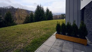 Ein modernes Haus mit Steinverkleidung und einem Rasen.