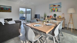 Un'area pranzo moderna con un tavolo di legno apparecchiato per quattro, circondata da sedie contemporanee.