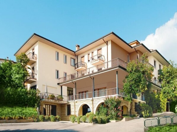 A multi-story hotel with a central courtyard, balconies, and a stone facade.