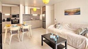 Un appartement moderne comprenant une cuisine, un coin repas et un salon.