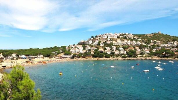 Une ville côtière avec des bâtiments construits sur une colline, dominant une plage.