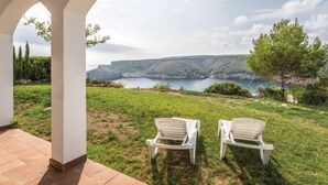 A patio with two white chairs overlooking a scenic landscape with a body of water and hills. - Mirador by Interhome (L'Escala)