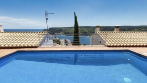 A rectangular swimming pool with a clear blue water surface, surrounded by a tiled deck. - Garbinell III by Interhome (L'Escala)