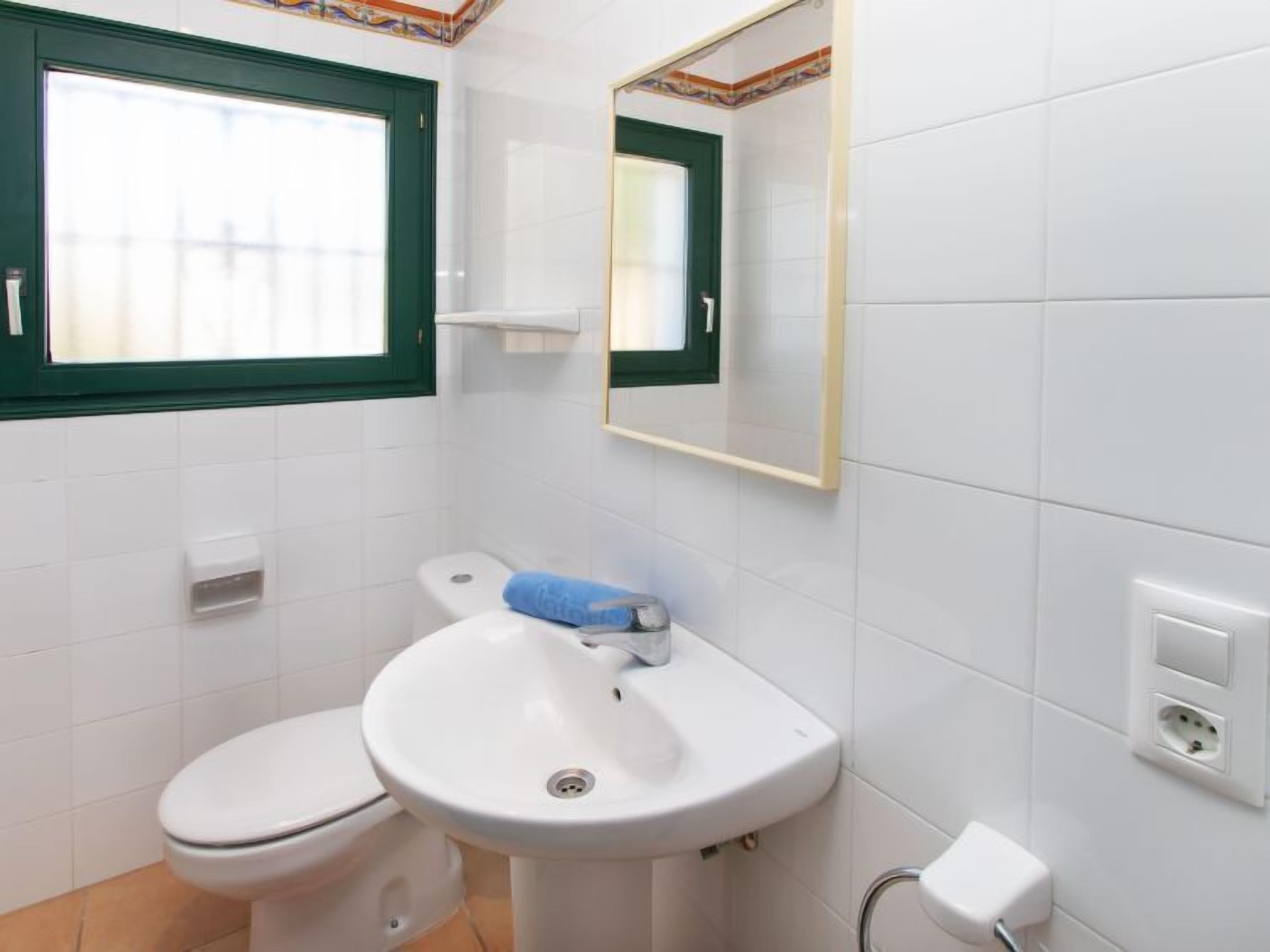 Ein Badezimmer mit Toilette, Waschbecken und Spiegel.