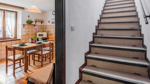 A staircase with wooden steps and black edges, leading to a door with a window. - Apartment Mila by Interhome (Colico)