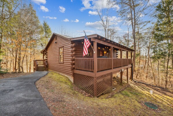 Guests can enjoy a tranquil outdoor space on the cabin's deck, surrounded by woods.