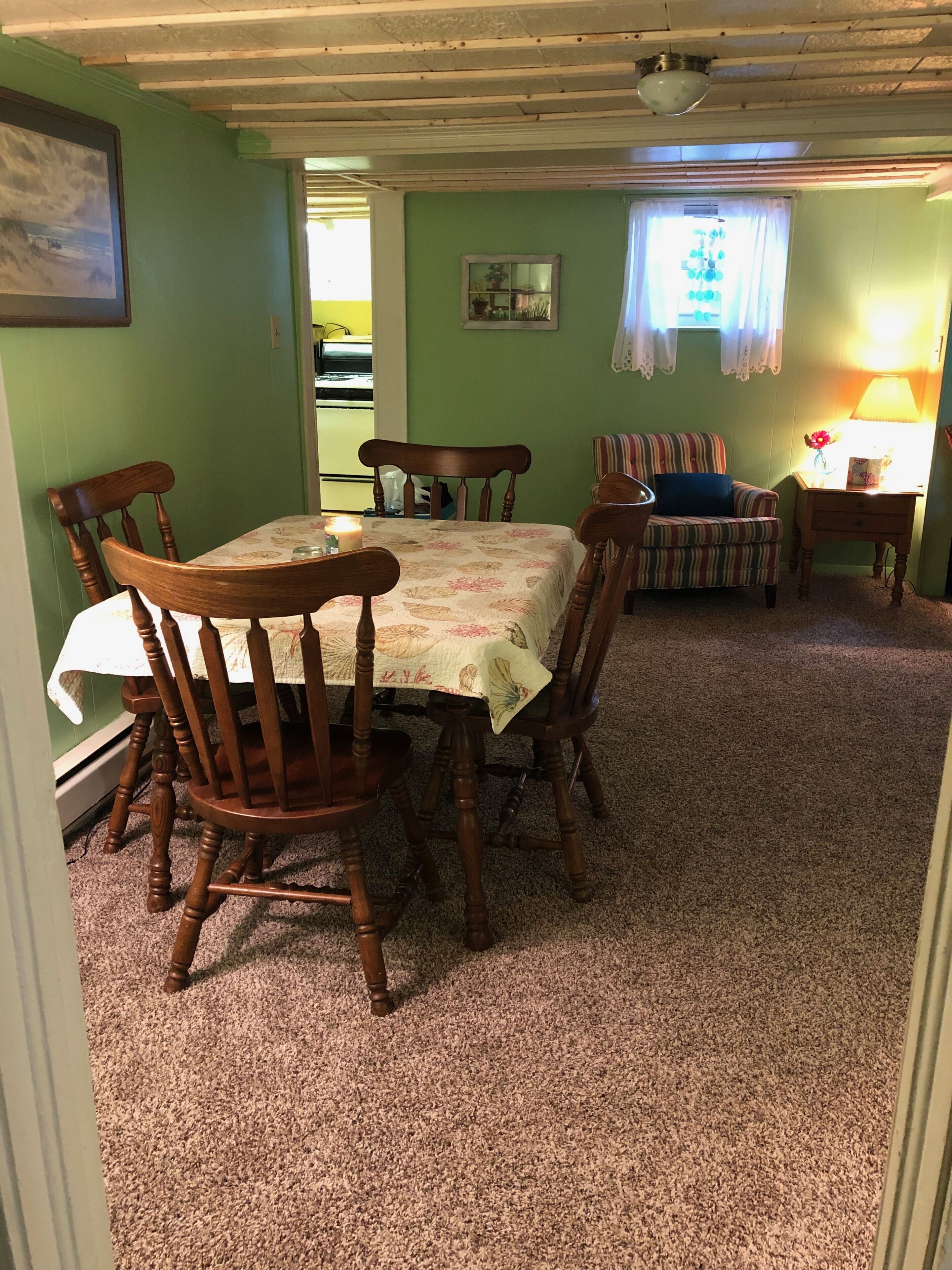 Un coin repas avec une table et des chaises, un canapé et une lampe.