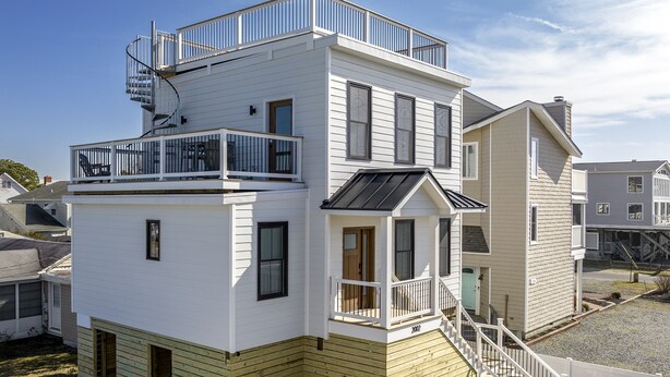 A two-story house with a balcony, a front porch, and a staircase leading to the second floor. - IN THE HEART OF DEWEY BEACH - 2002 Bayard Ave (Dewey Beach)