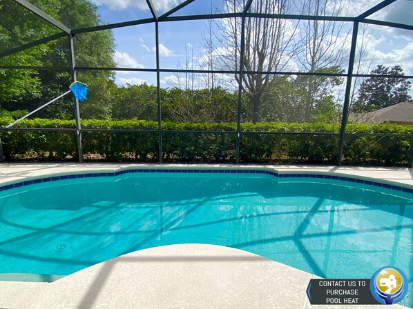 A clear blue pool surrounded by a metal fence, with a blue sky and trees in the background. - Modest Charmer W/ Private Pool (Clermont)