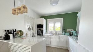 A modern kitchen with white cabinetry, a central island, and a window providing natural light.