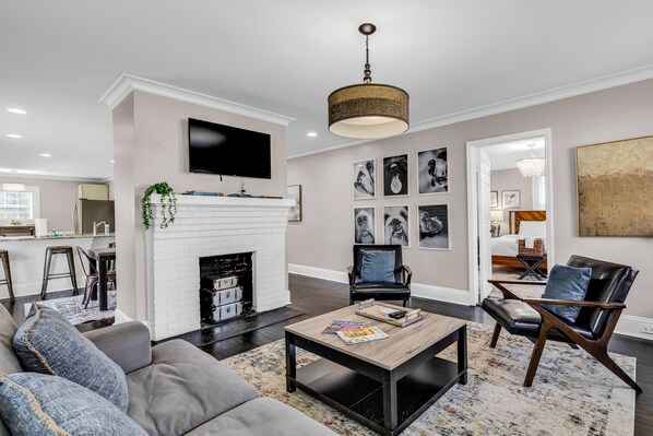Relax in this stylish living room with a flat-screen TV, fireplace, and comfortable seating area.