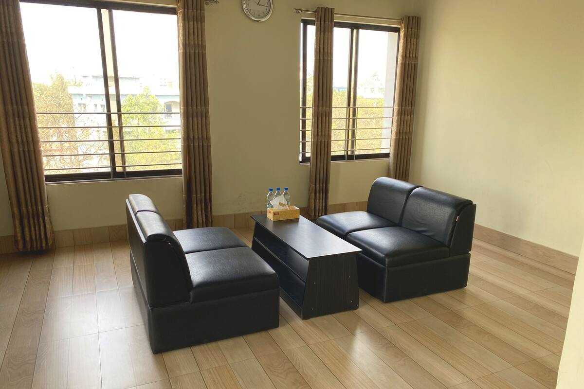 A room with a sofa set, a coffee table, and a clock on the wall.