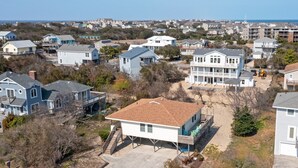 Un barrio residencial con casas, cielo despejado y una vista lejana del océano.