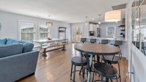 Una cocina moderna con armarios blancos, una isla central e iluminación colgante.