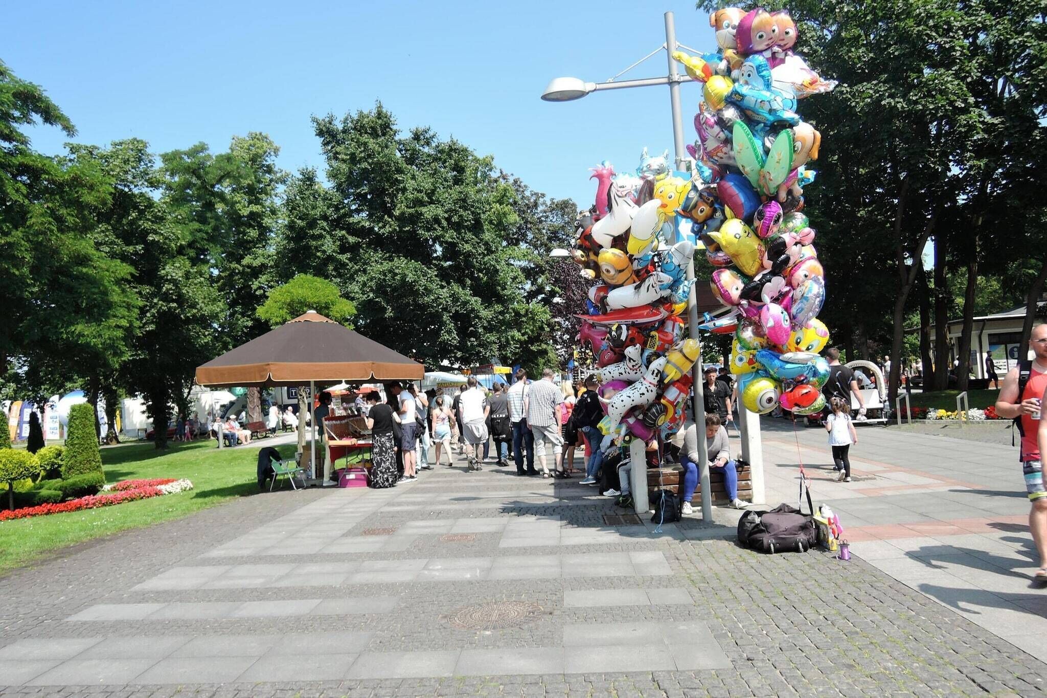 A public square with a gazebo, a street lamp, and a crowd of people.
