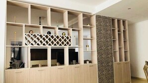A modern room with built-in shelving and a decorative wall panel.