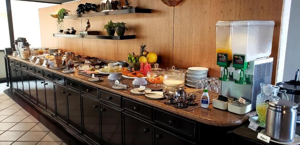 A breakfast buffet with various food items, a juice dispenser, and a water dispenser.