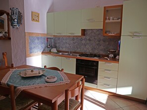 Frigorifero, forno, piano cottura, tavolo da pranzo