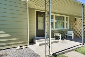 A house with a porch, a door, a window, and a table with chairs. - Fruita Vacation Rental: Walk to Downtown! (Fruita)