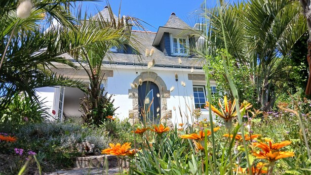 A house surrounded by lush greenery and vibrant flowers. - Maison golfe du morbihan (Locmariaquer)