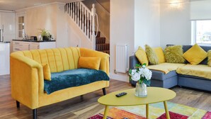 En moderne stue med en gul sofa, en grå sofa og et gult sofabord.