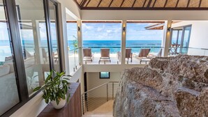 Ein Balkon mit Blick auf das Meer, eine Steinmauer und ein Blumentopf.