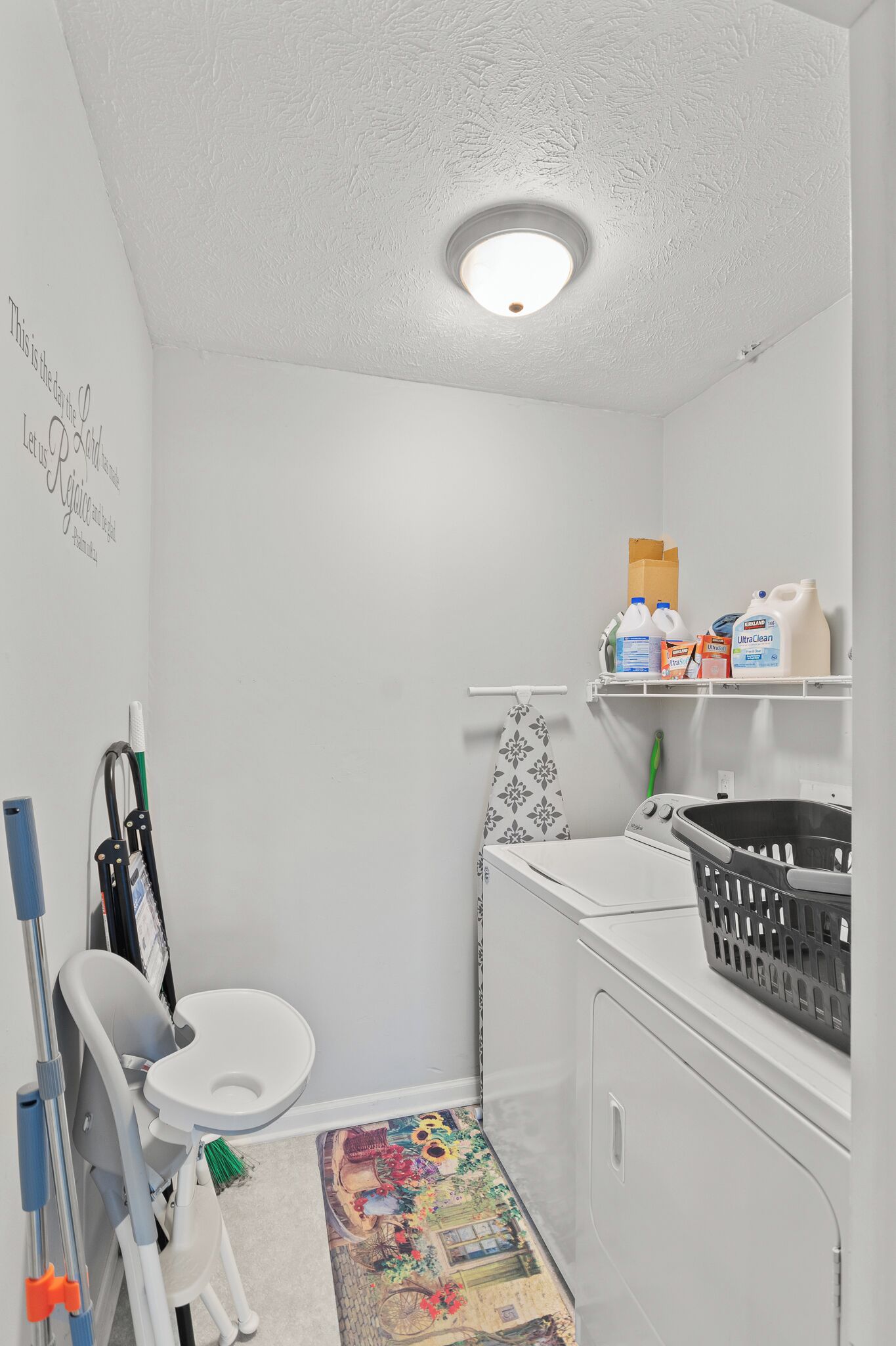 A compact bathroom with a toilet, washing machine, and laundry basket.
