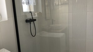 A modern bathroom with a glass-enclosed shower, a white washing machine, and a tiled floor. - Cosy park near Grande Plage awarded 3-star label (Carnac)