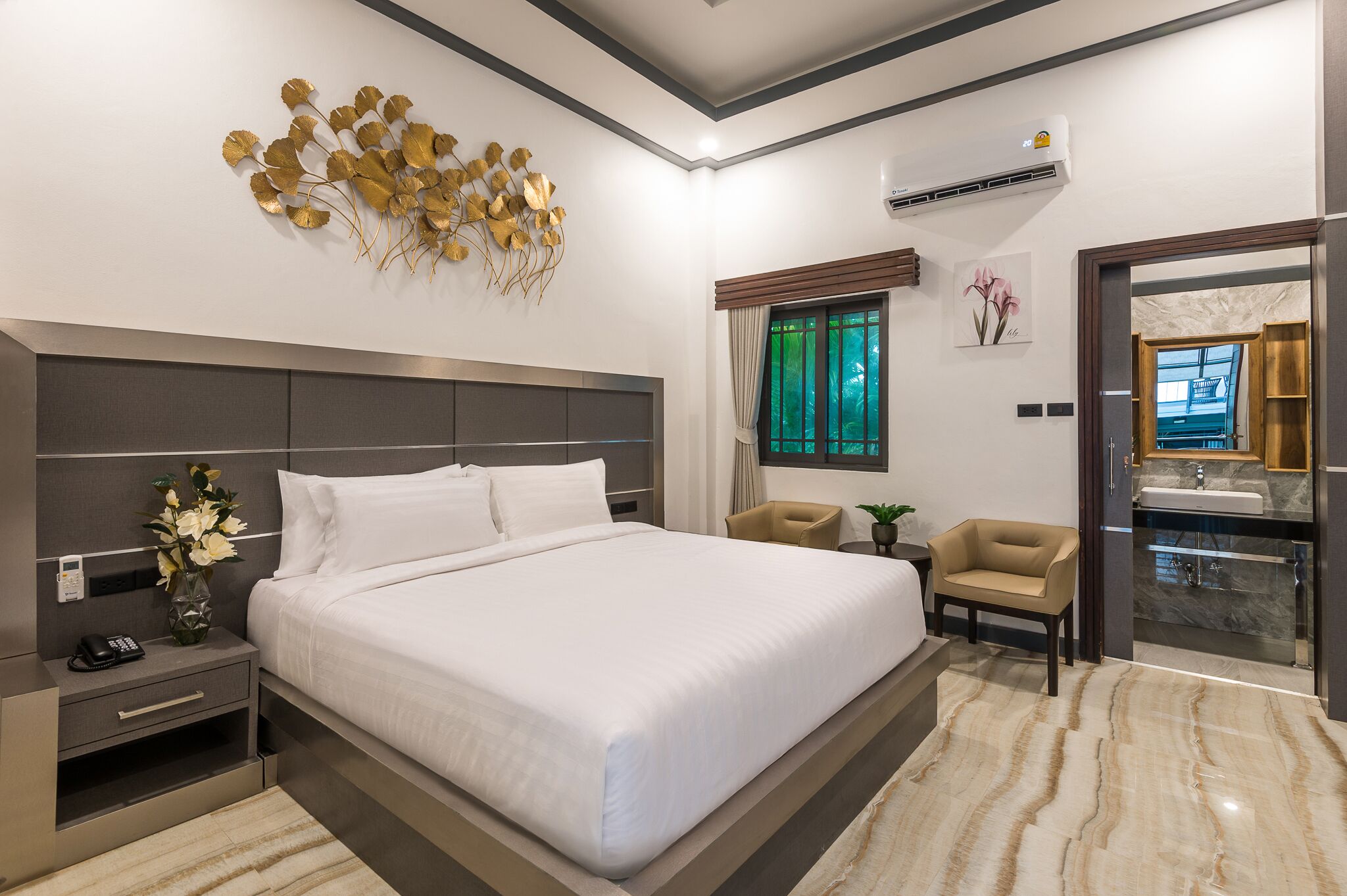 Una habitación de hotel moderna con una cama grande, mesitas de noche, un tocador con espejo y una ventana con cortinas.