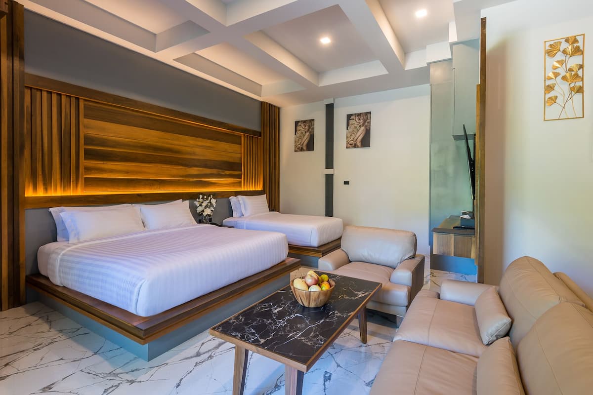 A modern hotel room with two beds, a sofa, a marble coffee table, and a wall-mounted TV.