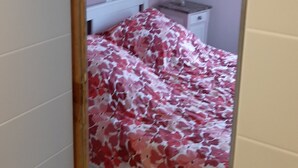 A bedroom with a bed, a nightstand, and a wall-mounted shelf. - Le chat Vert, bright and modern 2-room apartment (Strasbourg)