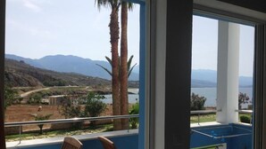 Un balcon avec vue sur les montagnes et un lac.