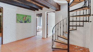 Eine Wendeltreppe mit Holzverkleidung und Metallgeländern, die zu einer oberen Etage führt.