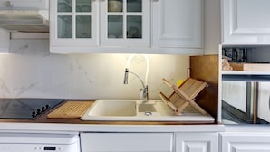 A kitchen with white cabinets, a double sink, a stove, and a wooden cutting board. - Superior apartment, 400m from the Palais des Festivals (Cannes)