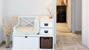 A modern interior with a white bench, a wall-mounted mirror, and a doorway leading to a bathroom. - Superior apartment, 400m from the Palais des Festivals (Cannes)
