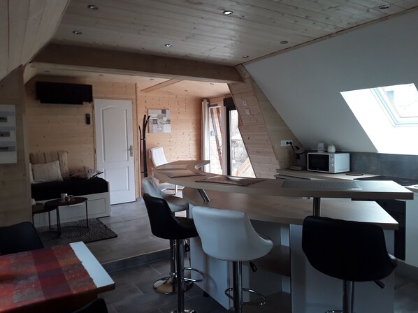 A modern kitchen with a large island, bar stools, and a dining table.