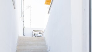 A set of white tiled stairs with blue accents leading to a door.