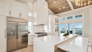 A modern kitchen with white cabinetry, stainless steel appliances, and a large island. - Grayt Joy|Private Community Beach Access|Unobstructed Gulf Views (Santa Rosa Beach)