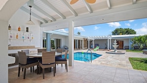 An outdoor patio with a pool, dining area, and a covered seating area. - Exquisite Courtyard Villa on St. Thomas East End / Ocean Views + Modern Comfort (St Thomas)