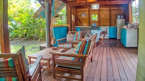 A wooden deck with outdoor seating and a kitchen area. - Le Parc aux Orchidées (Pointe-Noire)