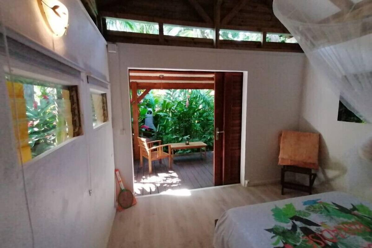 Un dormitorio con una cama, una mesa de madera y una silla frente a una puerta.