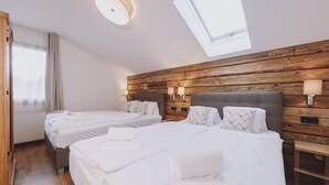 Ein Hotelzimmer mit zwei Betten, Holzvertäfelung an den Wänden und einem Oberlicht.