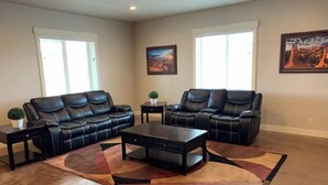 A living room with two black leather sofas, a coffee table, and a decorative rug. - Asixk 1 (Brand New) (Panguitch)