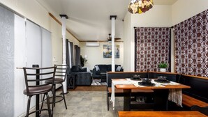 A compact living space with a dining area, a sofa, and a patterned wall. - 10 Seat Home theater. Office. Step-Free Entry. Seniors Welcomed. Pet Friendly! (Jim Thorpe)