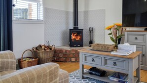 Una sala de estar acogedora con chimenea, televisor y un sofá cómodo.