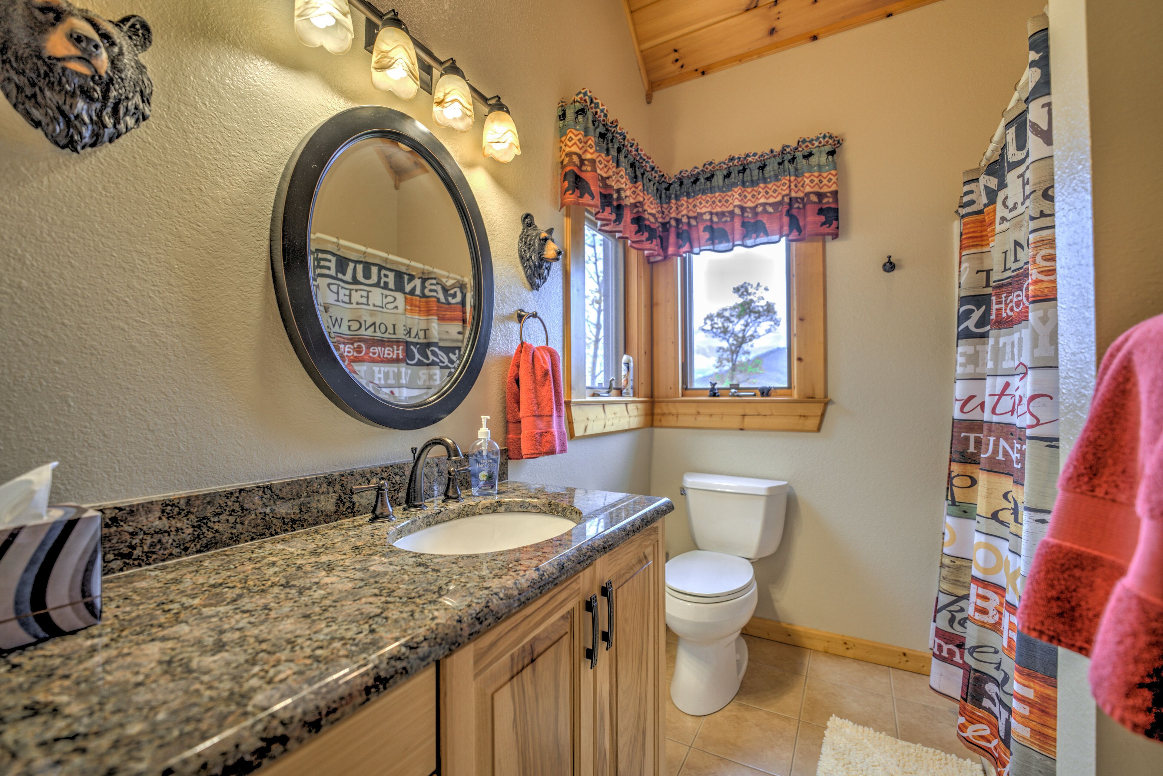Une salle de bain avec un comptoir en granit, un lavabo, des toilettes et un miroir.