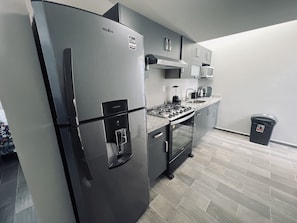 Eine moderne Küche mit Einbaukühlschrank, Herd, Mikrowelle und Spüle.