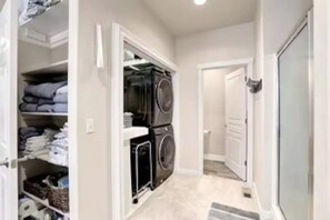 Une buanderie avec des paniers à linge empilés et une porte donnant sur une autre pièce.